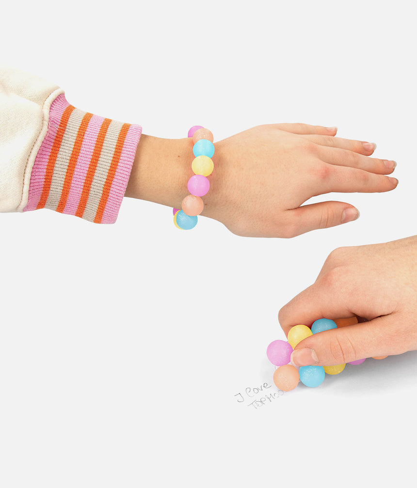 TOPModel eraser bracelet worn on a wrist and used to rub out pencil writing on paper