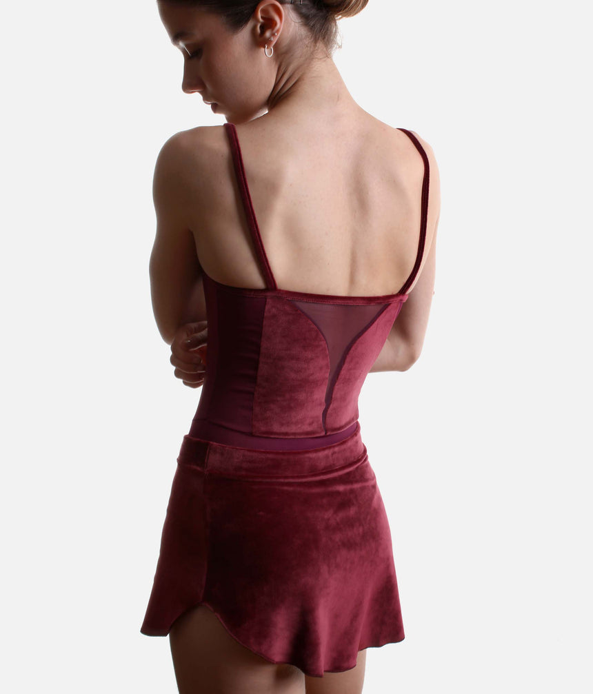 Back view of the Ioanna burgundy velvet skirt showing the matching waistband and rounded hem beneath a coordinating leotard.