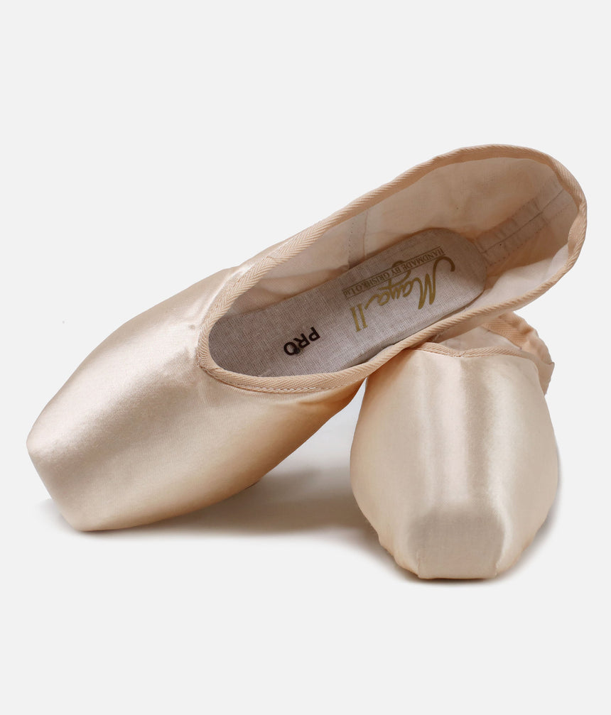A pair of pink Grishko Pointe Shoes - Maya II Pro with a high tapered vamp, narrow platform, and extended wings. The suede outsole is visible, along with the brand and model information inside the shoe.