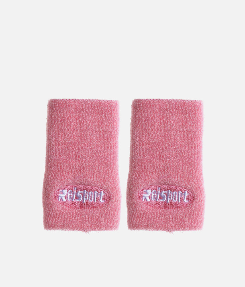 Pair of pink Reisport towelling wristbands laid flat with white embroidered logos