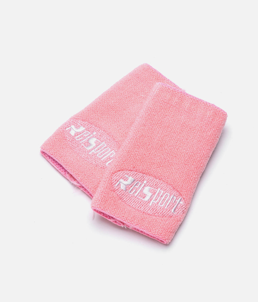 Overlapping pink Reisport gymnastics wristbands with white embroidered branding