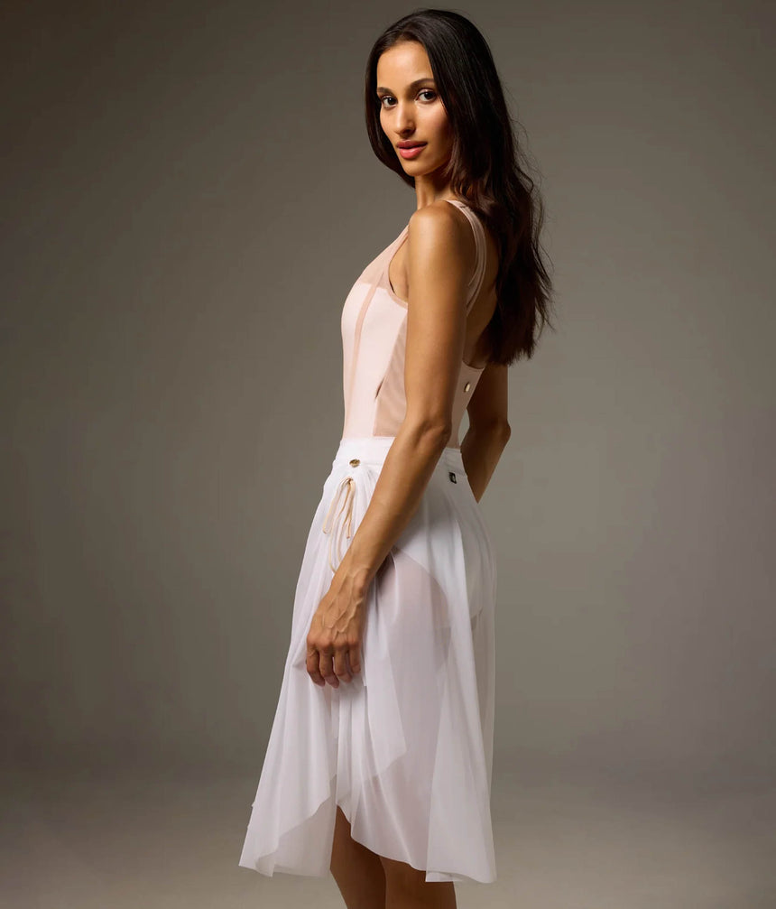 Rear-side view of Bodile Sofia Nougat Frost tank leotard styled with a separate longer white mesh rehearsal skirt.