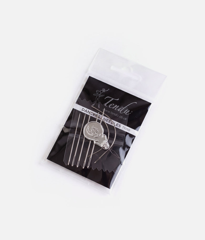 Angled view of the Tendu T1050 needle set in clear packaging, showing the curved needles, straight needles and wire-loop threader.