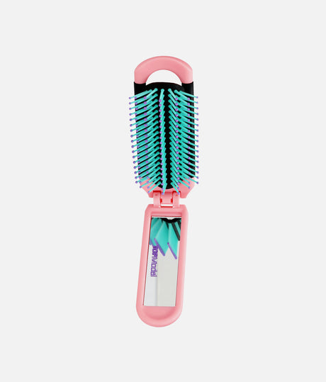 A pink folding hairbrush with teal and purple bristles and a small mirror on the handle, shown against a light gray background.