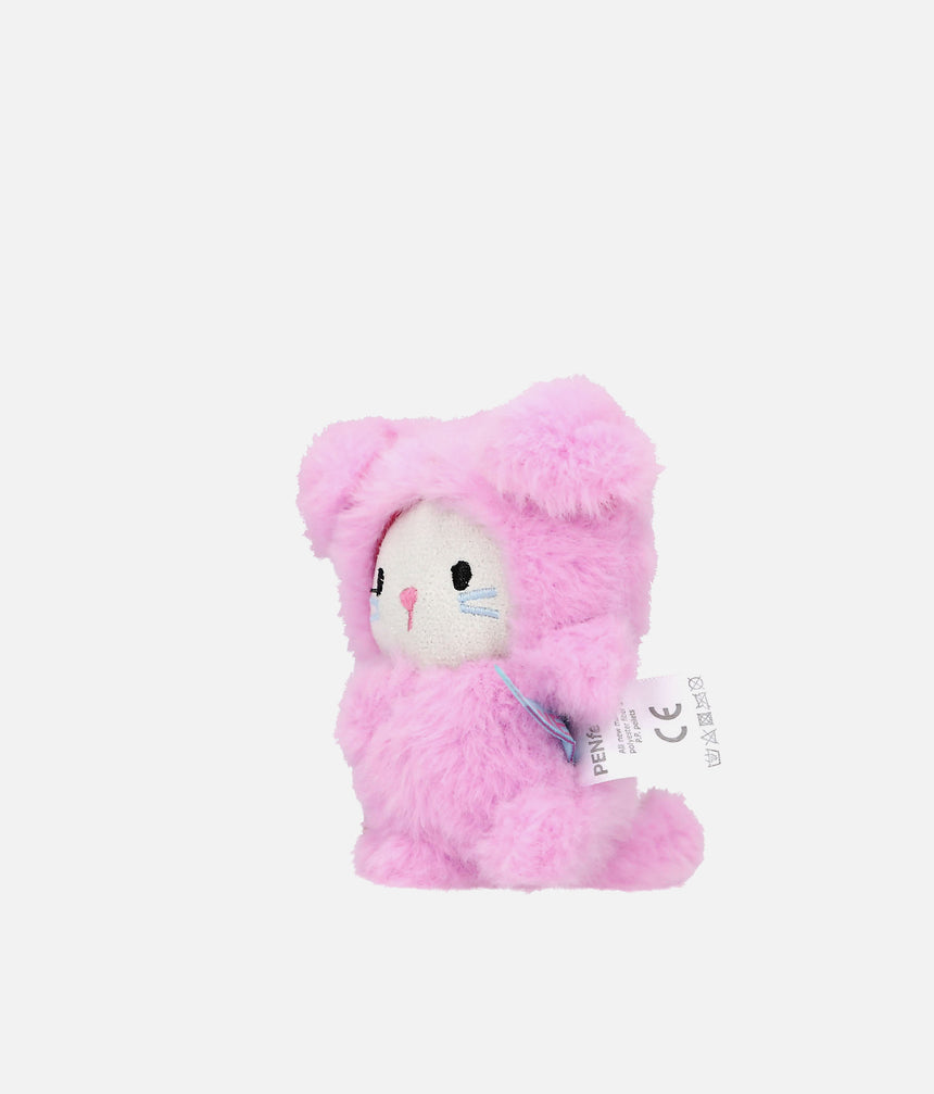 A pink plush bunny toy wearing a fuzzy pink bunny suit, with a white face and embroidered black, pink, and blue facial details. A small hangtag is attached on the right side, photographed against a clean light gray background.