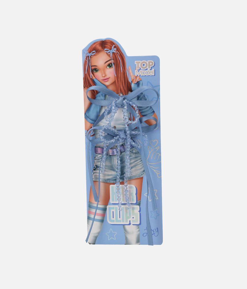 Two blue TOPModel KPOP ribbon bow hair clips with clear faceted bead strands and long tails on a Lexy presentation card