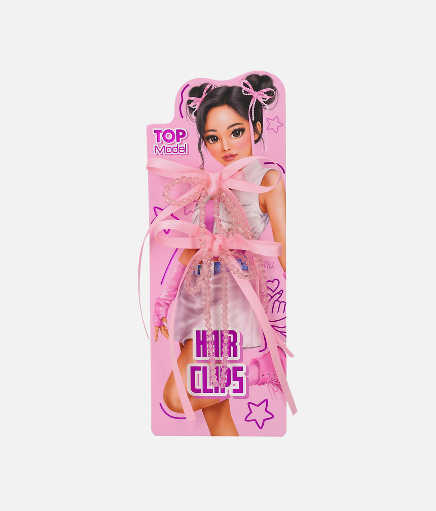 Two pink TOPModel KPOP ribbon bow hair clips with clear faceted bead strands and long tails on a Yena presentation card