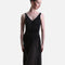 A woman modeling a sleeveless black dance dress with a V-neckline, solid black bodice, and flowing sheer black skirt panels, photographed against a light gray studio background.
