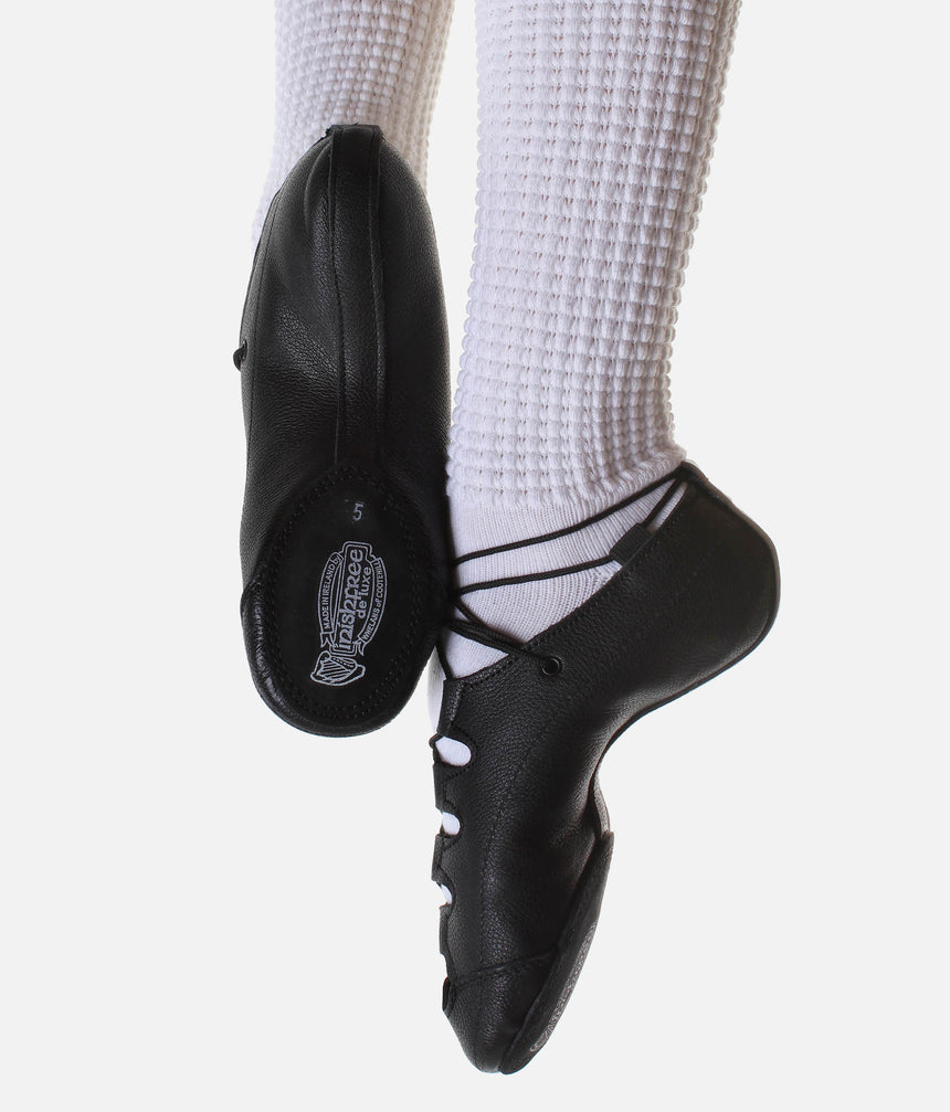 Inishfree Aoife black Irish dancing pumps worn with white poodle socks, showing the side profile and split sole