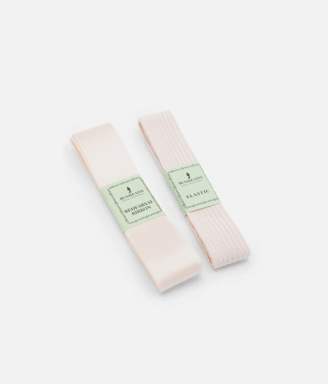 Bunheads BH315 pale pink satin ribbon and ribbed elastic folded with green paper bands, shown at an angle