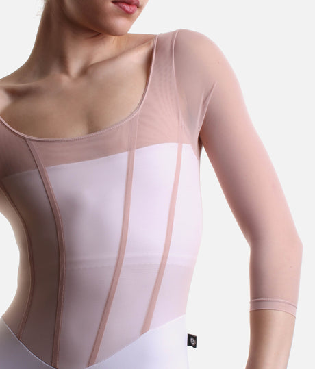 Close-up of Bodile Sofia Frost Nougat leotard, showing blush mesh, pink corset-style seams and white bodice panels.