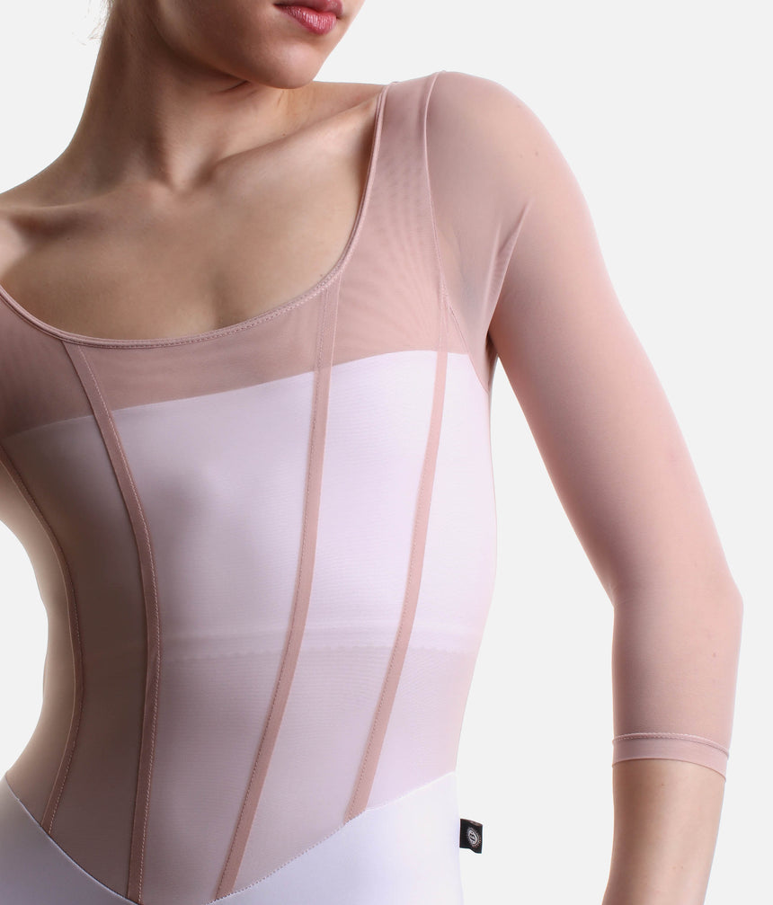 Close-up of Bodile Sofia Frost Nougat leotard, showing blush mesh, pink corset-style seams and white bodice panels.