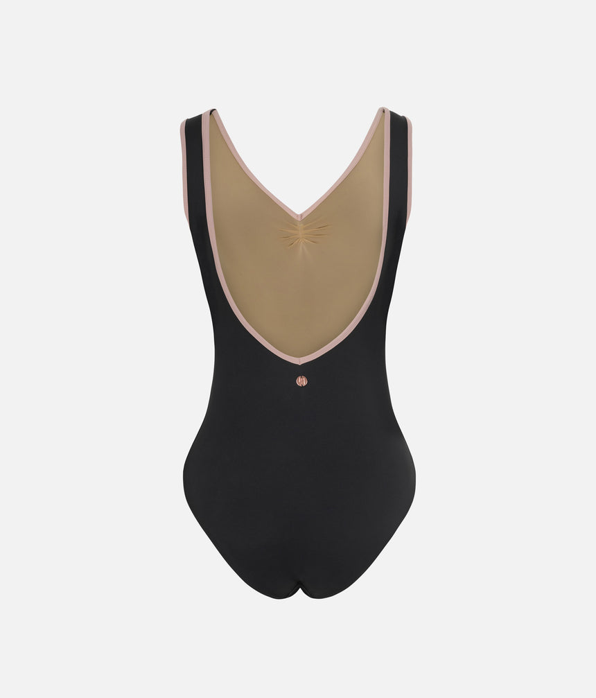 A black one-piece bodysuit with a large beige V-shaped back panel, trimmed with light pink piping and featuring a small metallic star detail at the center.