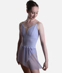 Front view of the Grishko Celine skirt in pale lilac, with one side held out to show the curved mock-wrap hem over a pale blue leotard.