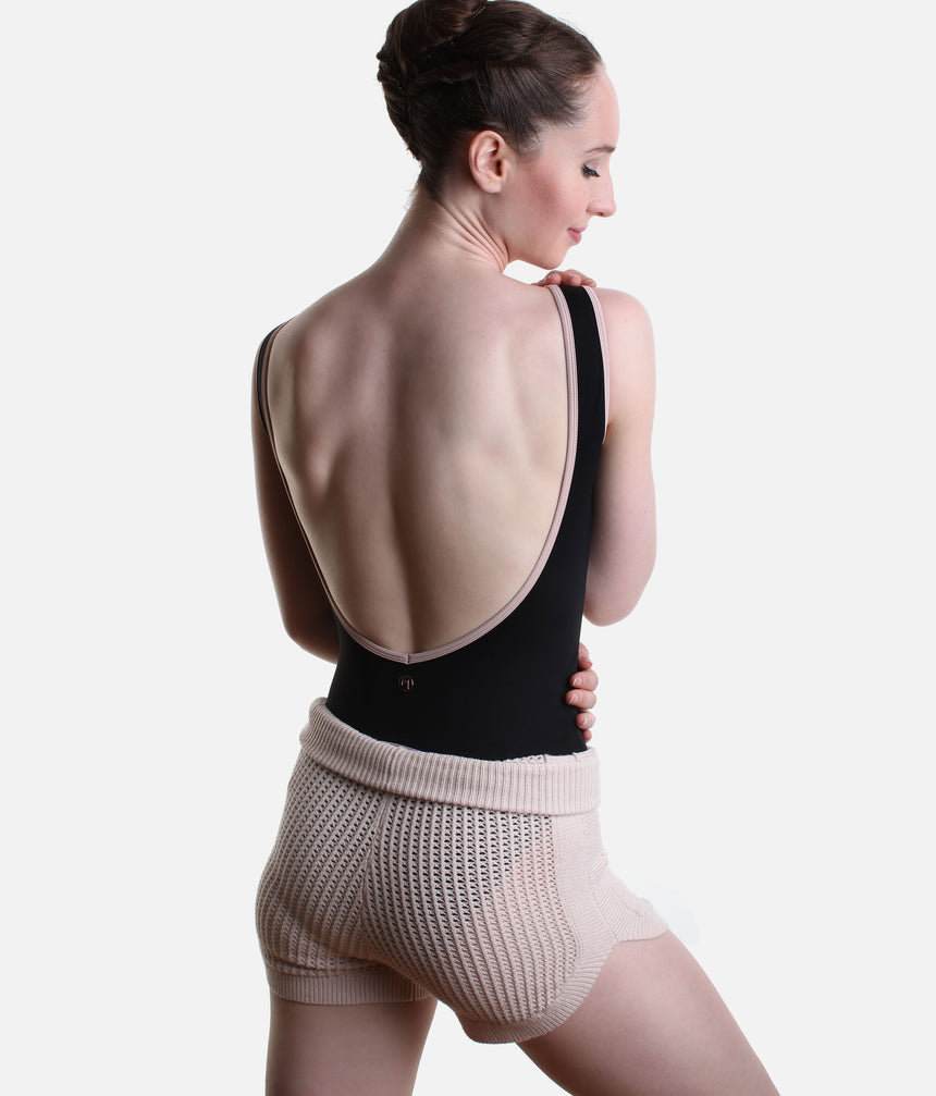 Back view of Pink Capezio Anderson knit shorts worn over a black leotard, showing the open stitch texture and folded ribbed waist.