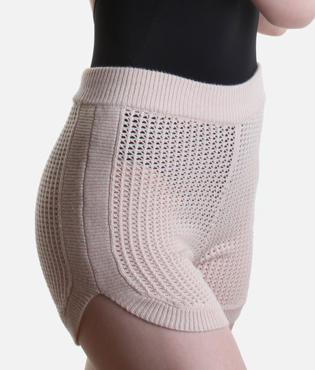 Close-up of Pink Anderson shorts showing the ribbed side band, small side slit and pointelle knit with a black leotard visible beneath.