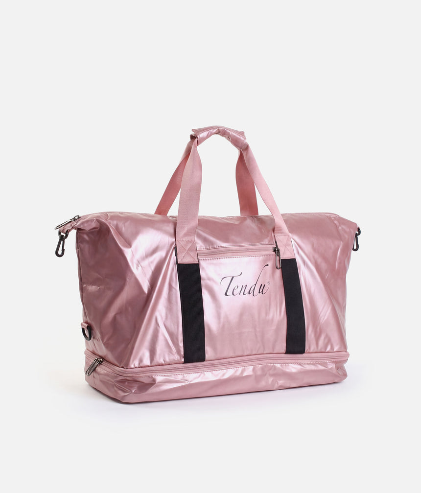 A metallic pink duffel bag with black side straps and a front zippered pocket featuring the script brand name 'Tendu'.