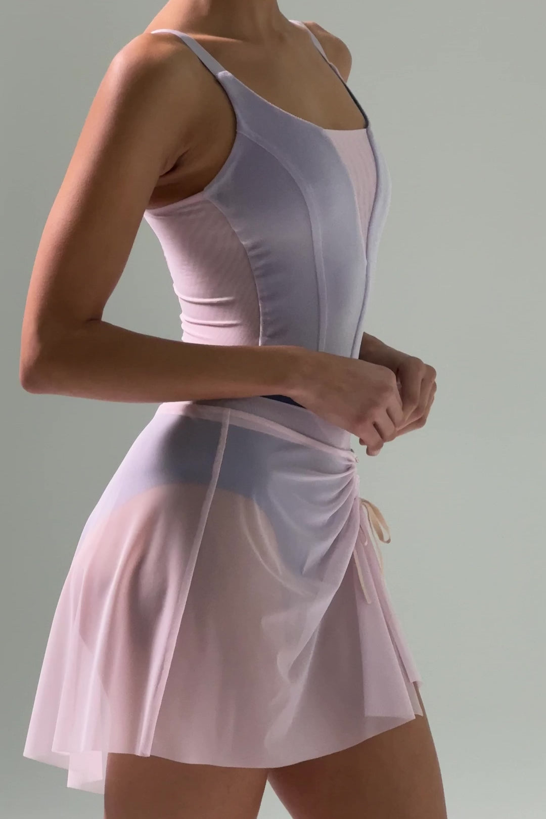 Video of Dancer wearing a blue-grey Bodile Mika mesh ballet skirt with gathered ruching and a left-side split over a long-sleeve leotard.