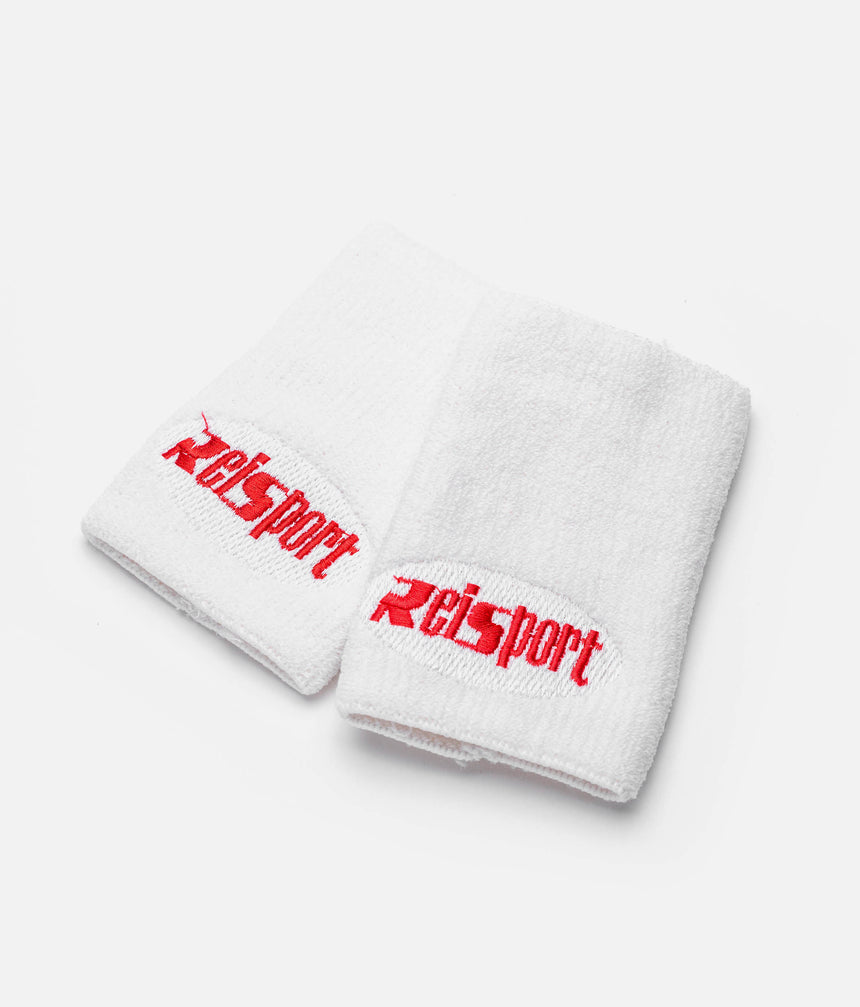 Overlapping white Reisport gymnastics wristbands showing towelling texture and red logos