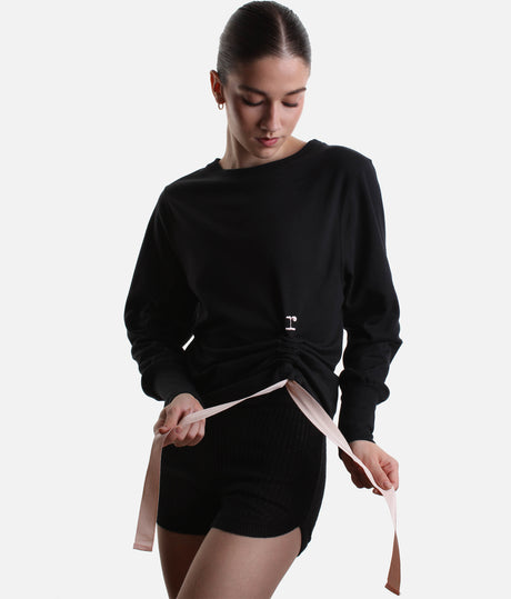 Close-up of Repetto S0797 black sweatshirt showing the round neckline, small r logo and gathered side with a pale-pink bow.