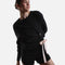 Model wearing Repetto S0797 black side bow sweatshirt with a pale-pink tie, gathered asymmetric hem and black trousers.