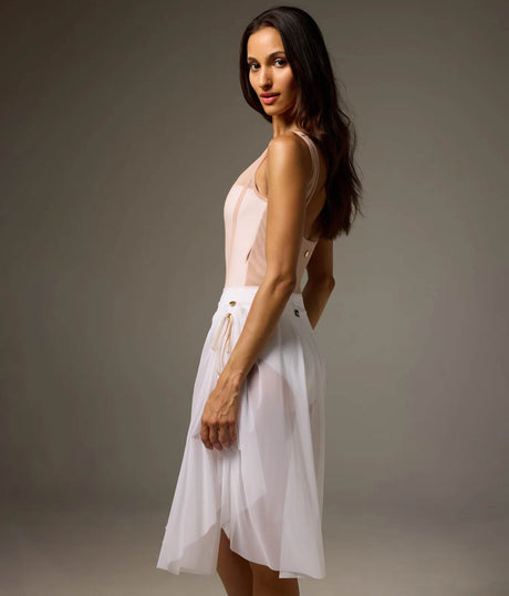 Rear-side view of Bodile Sofia Nougat Frost tank leotard styled with a separate longer white mesh rehearsal skirt.
