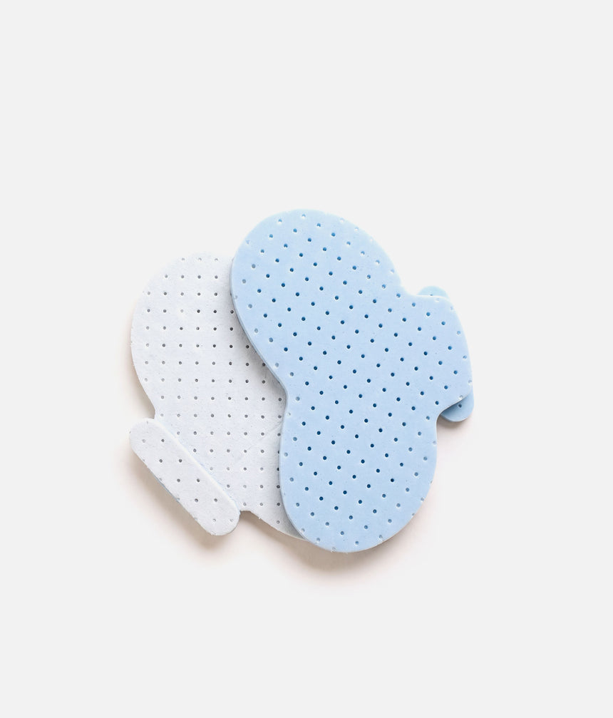 Two overlapping Tendu pointe shoe inlays showing the pale blue foam side, white facing and perforated surface.