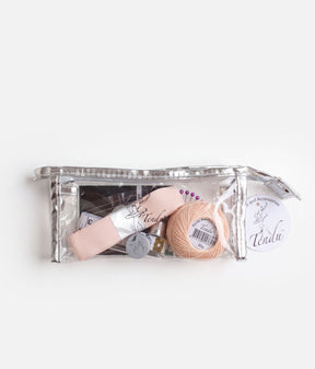 Tendu Dancer’s Sewing Kit in a clear zipped pouch with silver trim, showing pink ribbon, darning thread and sewing tools inside.