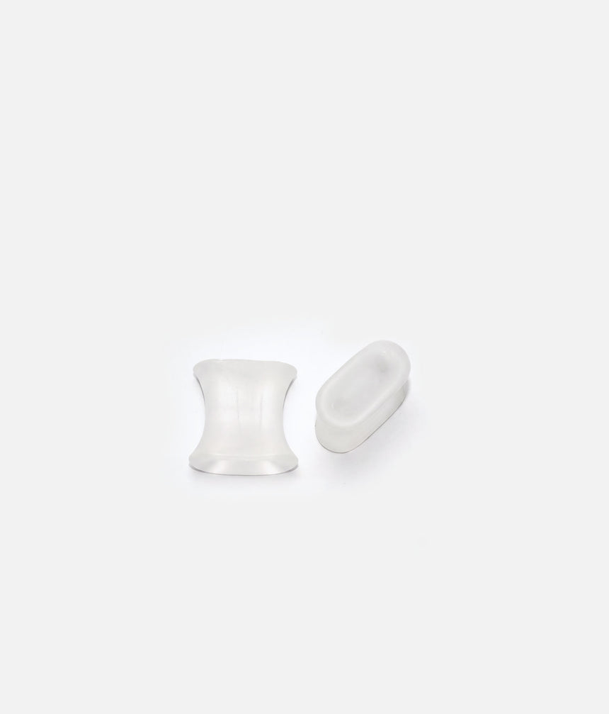 Two translucent Tendu gel toe spacers shown from different angles, highlighting their curved sides and wider edges.