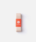 Pale pink-beige Virtisse Stretch Ribbon folded beneath an orange paper band with the white Virtisse flower logo.