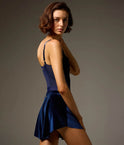 Side and back view of the Bodile Zara velvet ballet skirt in navy, showing its raised side hem.